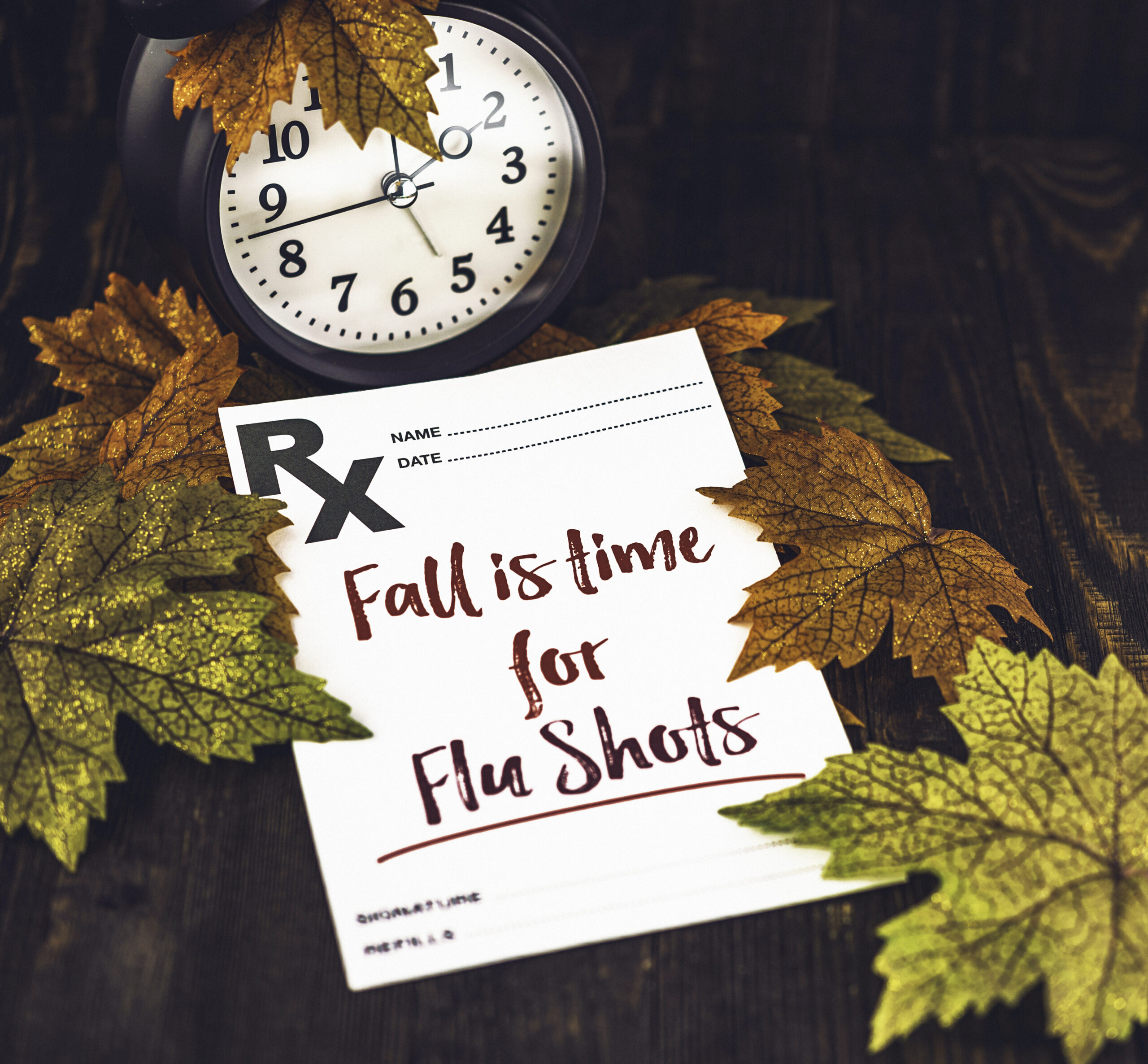 fall leaves, a clock, and a prescription pad with Fall is time for flu shots